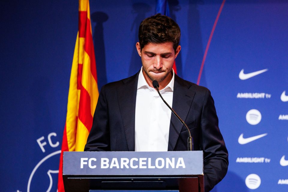 a man stands behind a podium that says fc barcelona