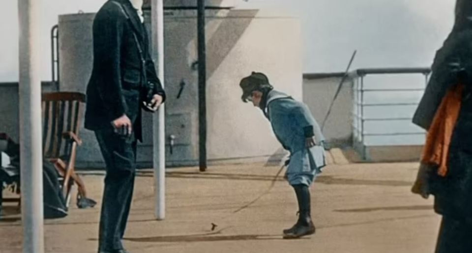 a man in a suit is standing next to a child on a leash