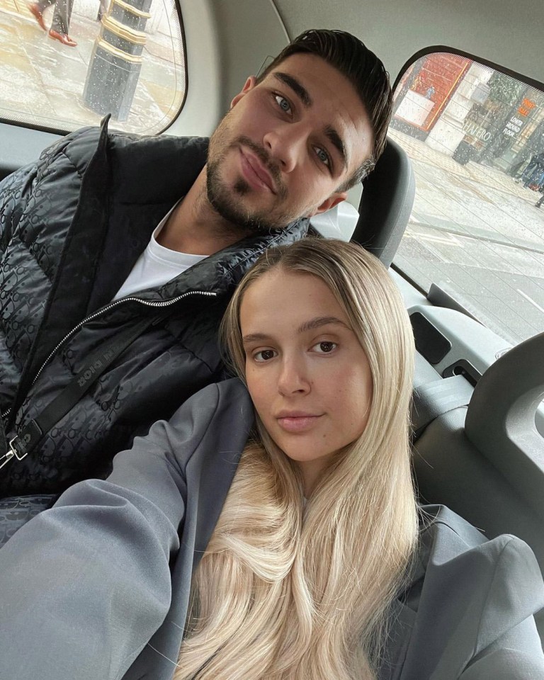 a man and a woman are posing for a picture in the back seat of a car