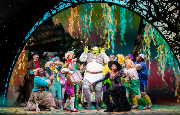 shrek is surrounded by a group of people on a stage