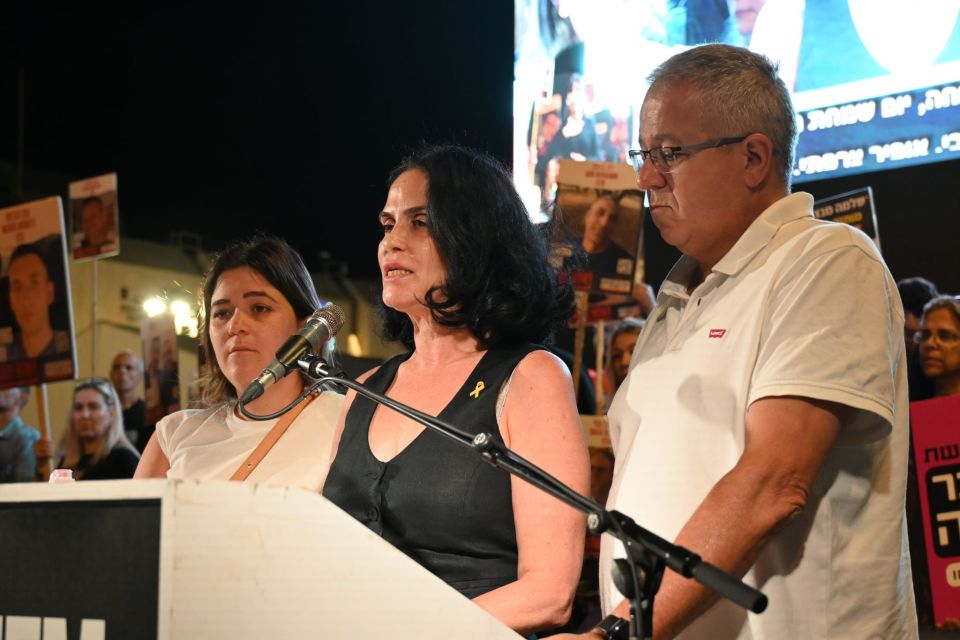 a man in a white levi 's shirt stands next to a woman at a podium