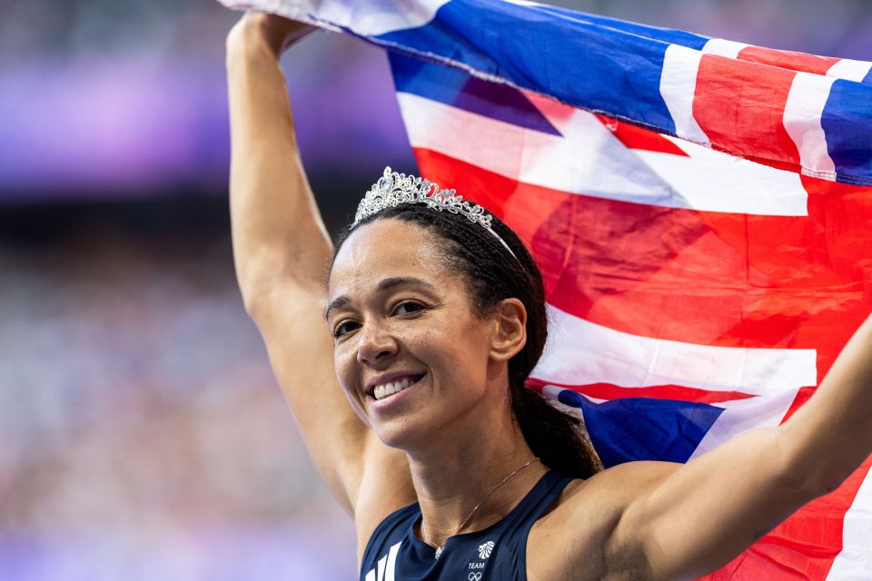 a woman wearing a tiara holds a british flag over her head