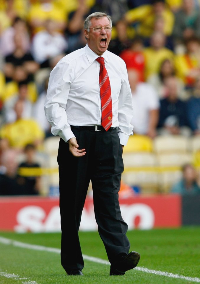 a man in a white shirt and red tie shouts on a soccer field