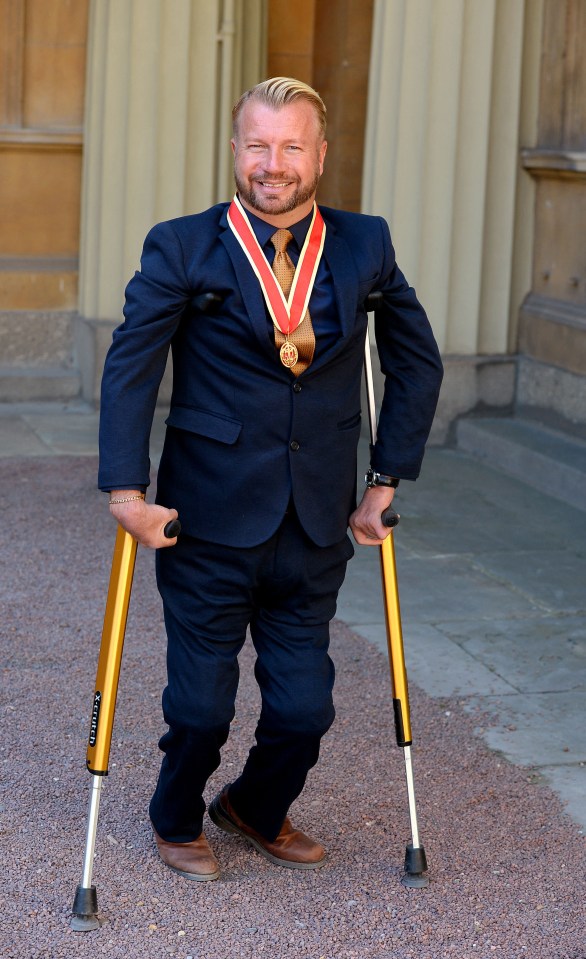 a man with crutches is wearing a medal around his neck