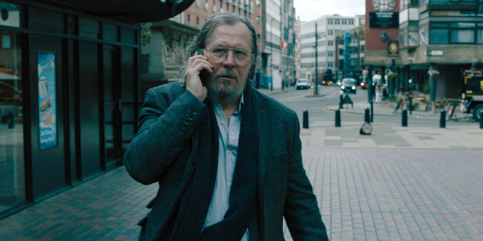 a man walking down a street talking on a cell phone