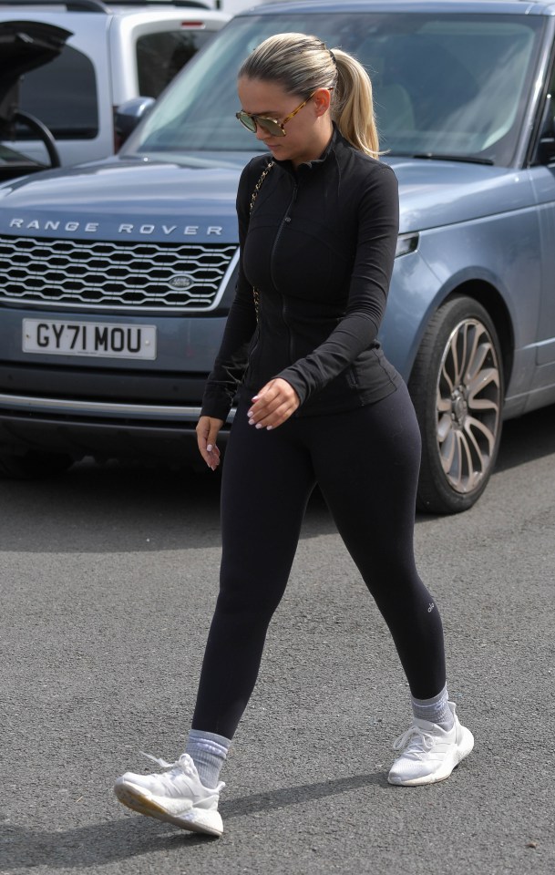 a woman walking in front of a range rover with a license plate that says gy71 mou