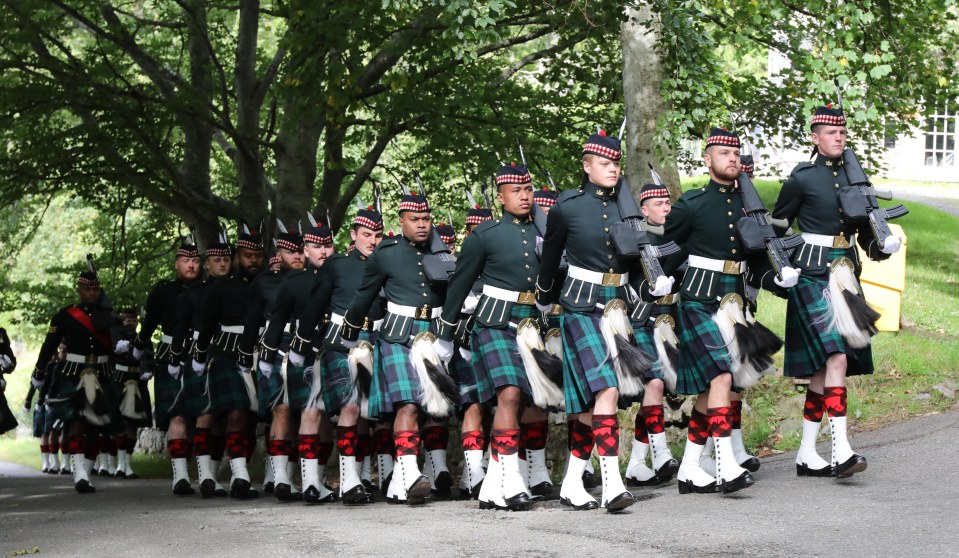 a group of men in kilts marching in a line