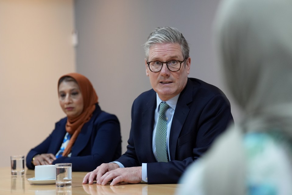 a man in a suit and tie sits at a table with two women