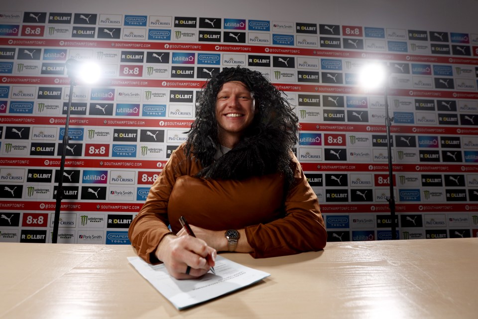 a man wearing a wig is signing a document