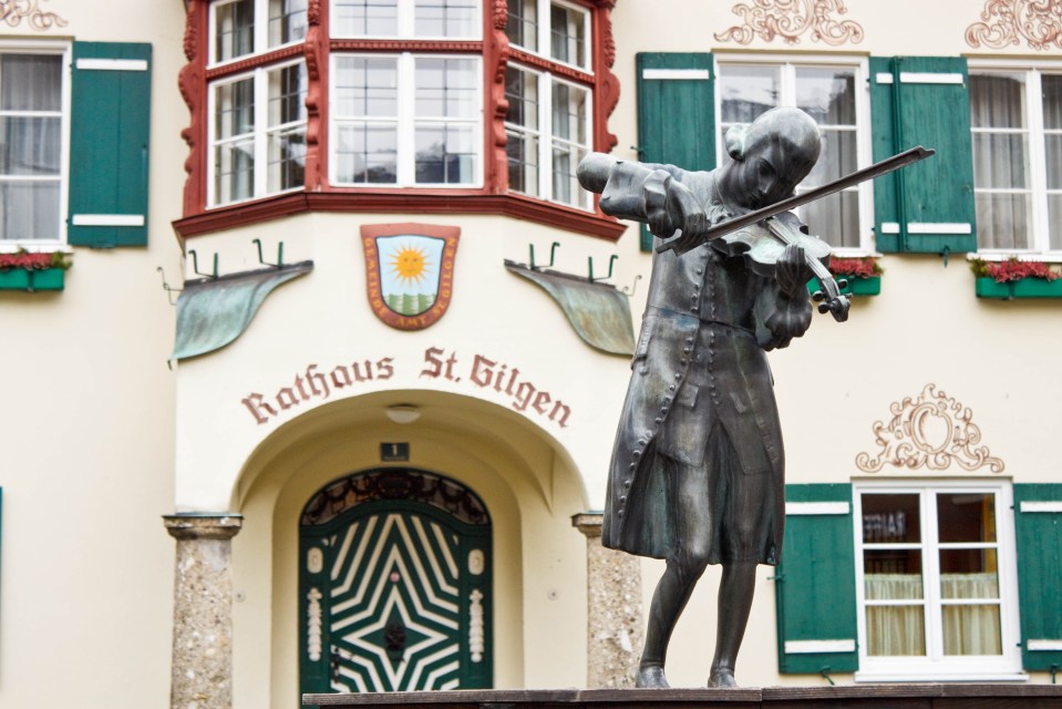 a statue in front of a building that says rathaus st. gilgen