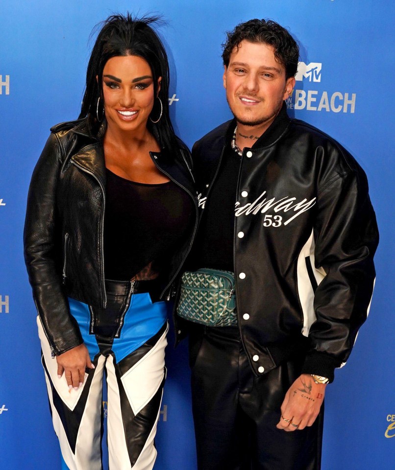 a man and a woman are posing for a picture in front of a mtv beach sign