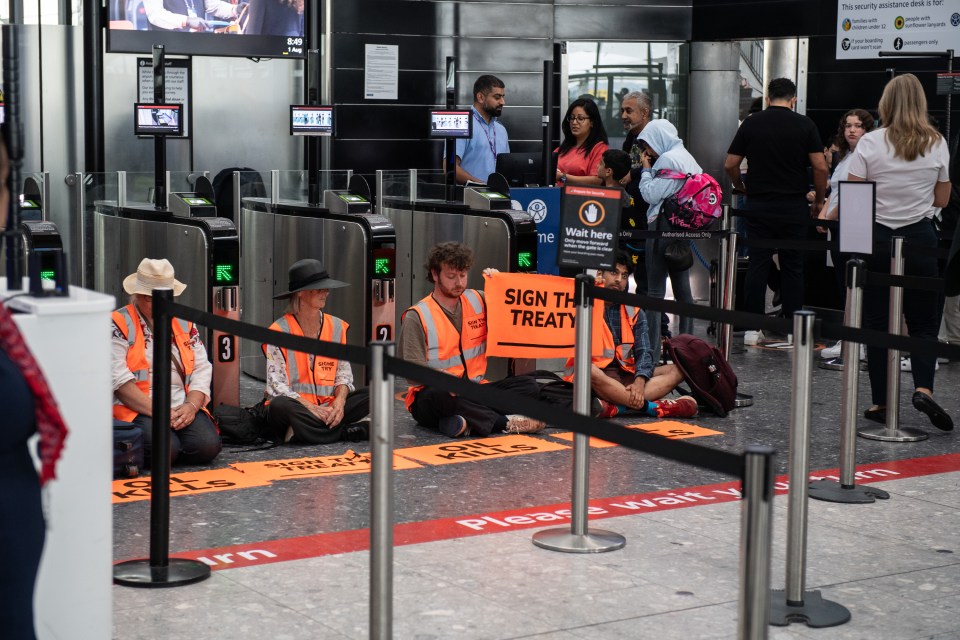 people sitting on the ground holding signs that say sign the treaty