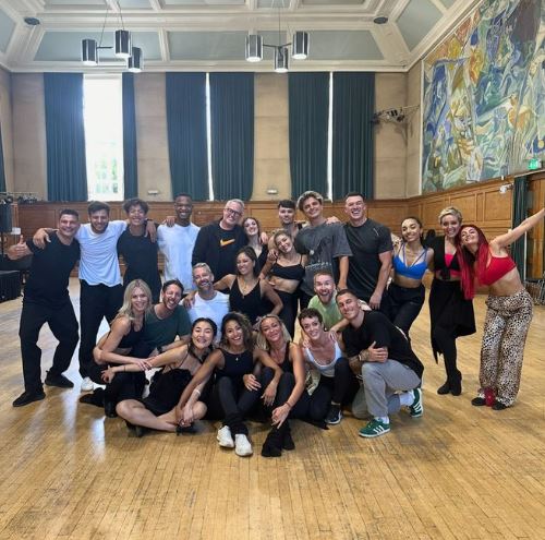 a group of people are posing for a picture in a dance studio .