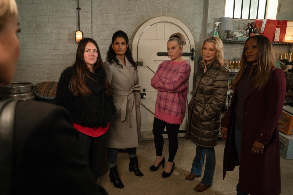 a group of women standing in front of a door that says ' a ' on it