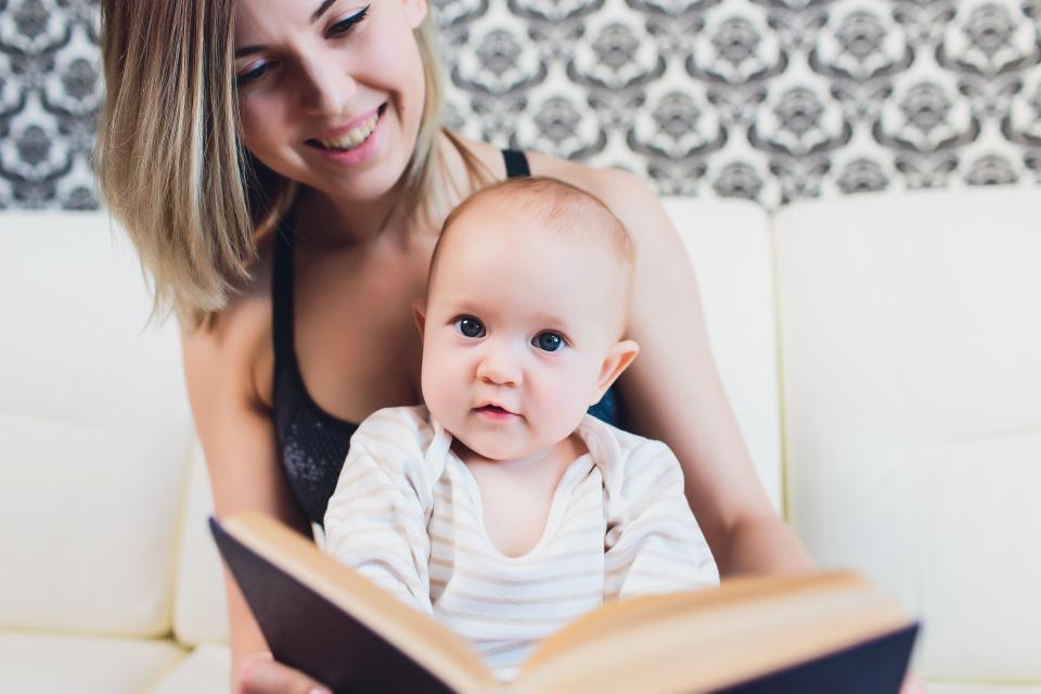 a woman is reading a book to her baby