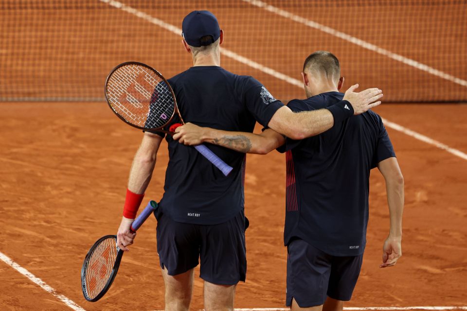 two tennis players are hugging each other while holding wilson racquets