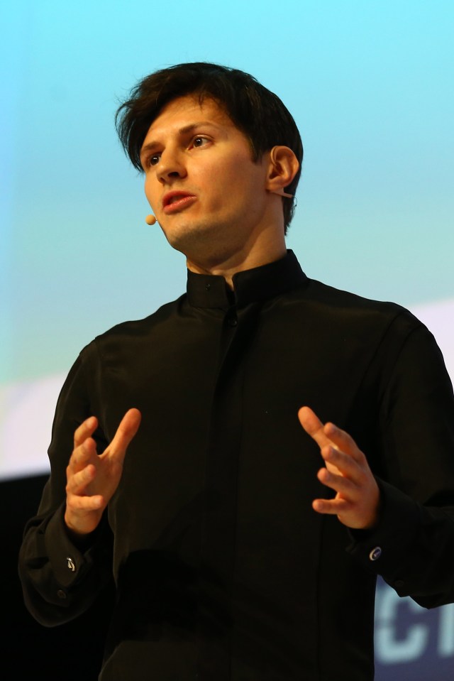 a man in a black shirt is speaking into a microphone