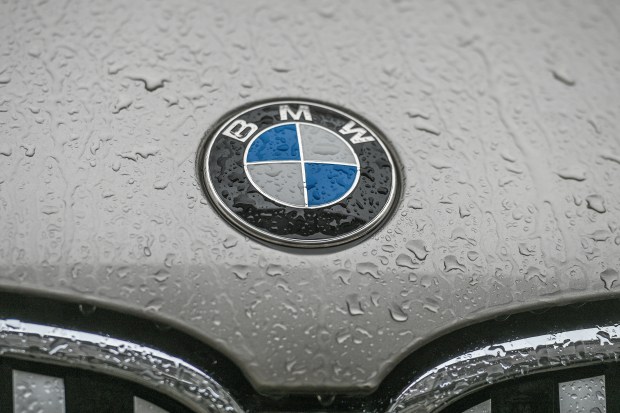 a close up of a bmw logo with water drops on it