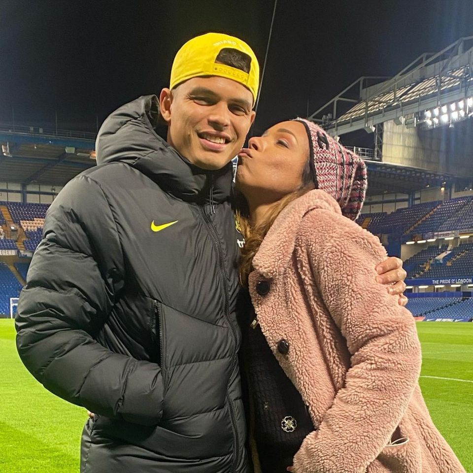 a man in a nike jacket kisses a woman on the cheek