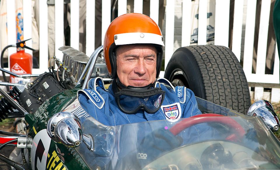 a man wearing a sparco helmet sits in a race car