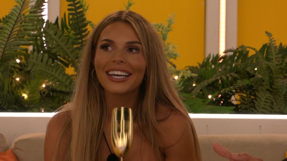 a woman sitting on a couch holding a glass of champagne