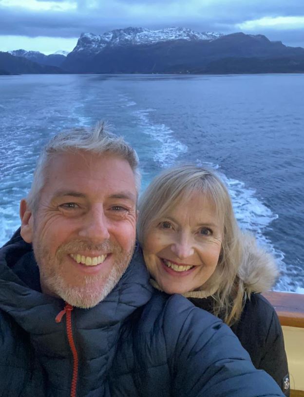 a man and woman are posing for a picture on a boat