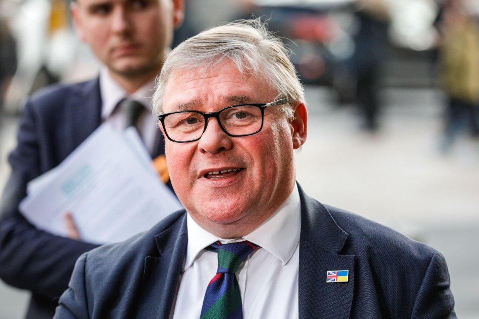 a man in a suit has a british flag pin on his jacket