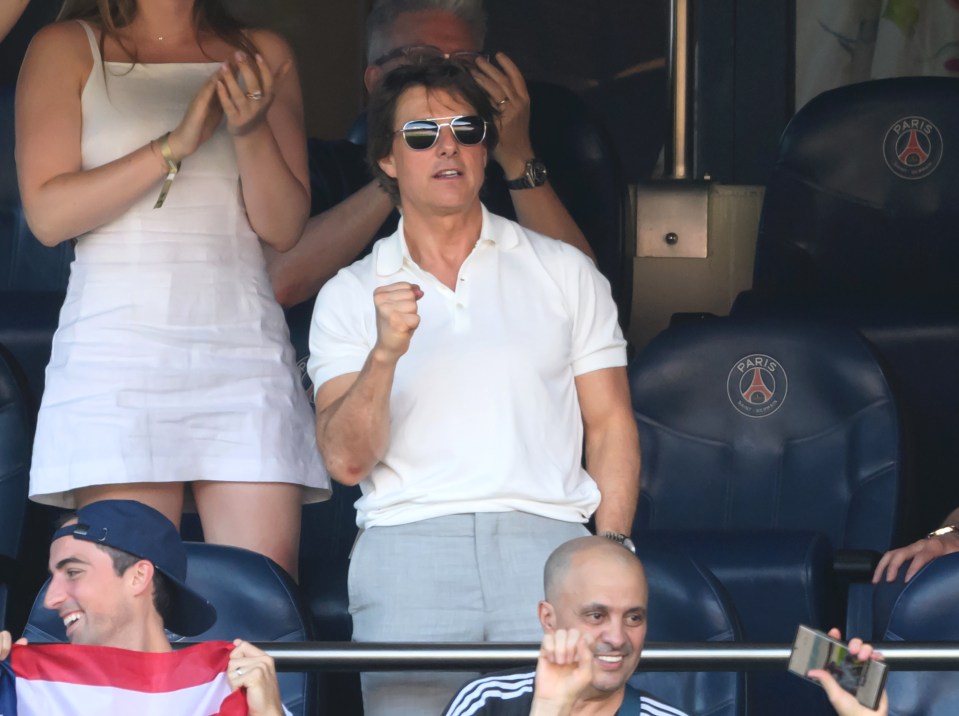 a man wearing sunglasses stands in front of a paris seat