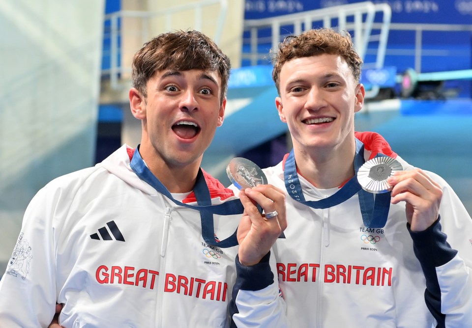 two great britain athletes hold up their medals