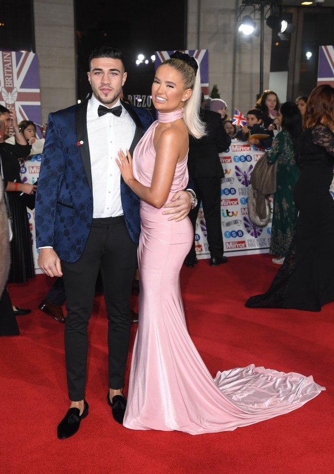 a woman in a pink dress stands next to a man in a blue suit