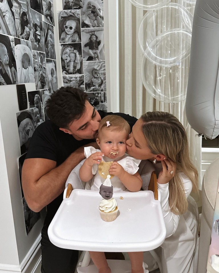 a baby in a high chair with a cupcake with a picture of a baby on it