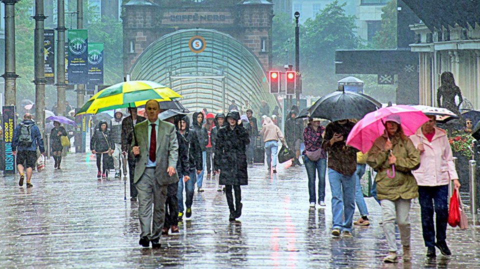 a group of people walking in the rain with umbrellas in front of a building that has the number 8 on it