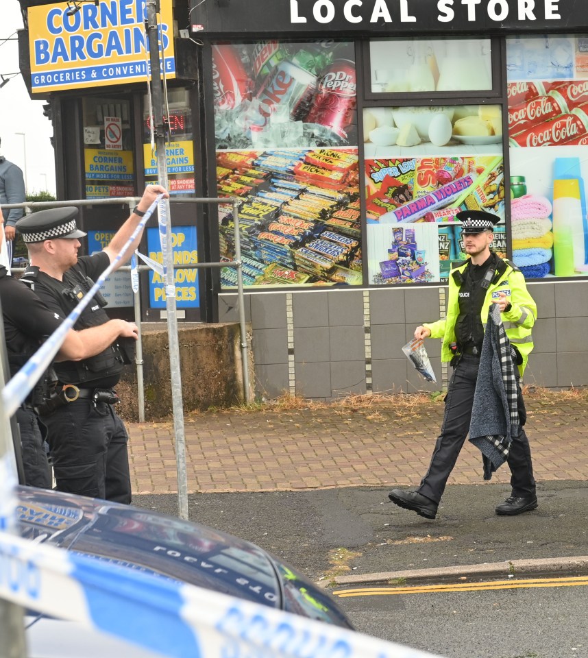 a corner bargain store is surrounded by police