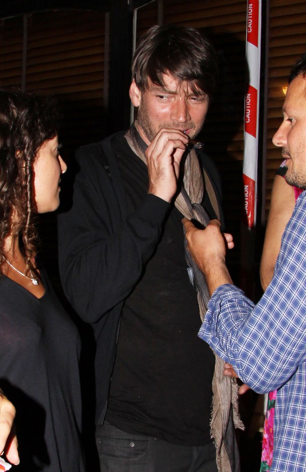 Blur's Alex James pictured smoking by the entrance in 2009