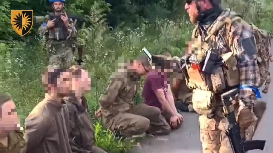 The captured POWs watched over by Ukrainian soldeirs