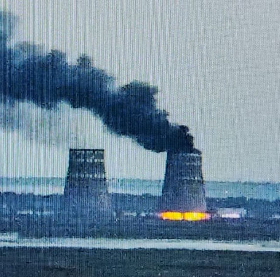 smoke is coming out of two cooling towers at a nuclear power plant .