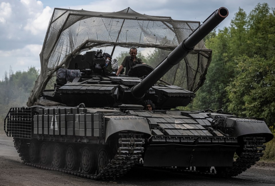 a man sits on top of a tank with the number 4 on the side