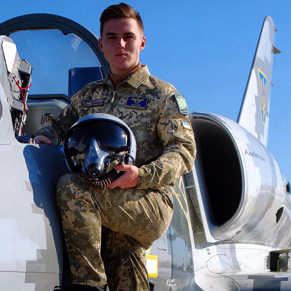 a man in a military uniform is sitting in the cockpit of a fighter jet