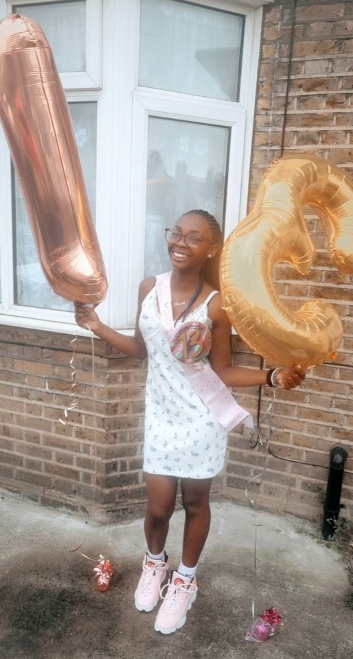 a girl in a white dress is holding balloons in the shape of numbers 1 and 3