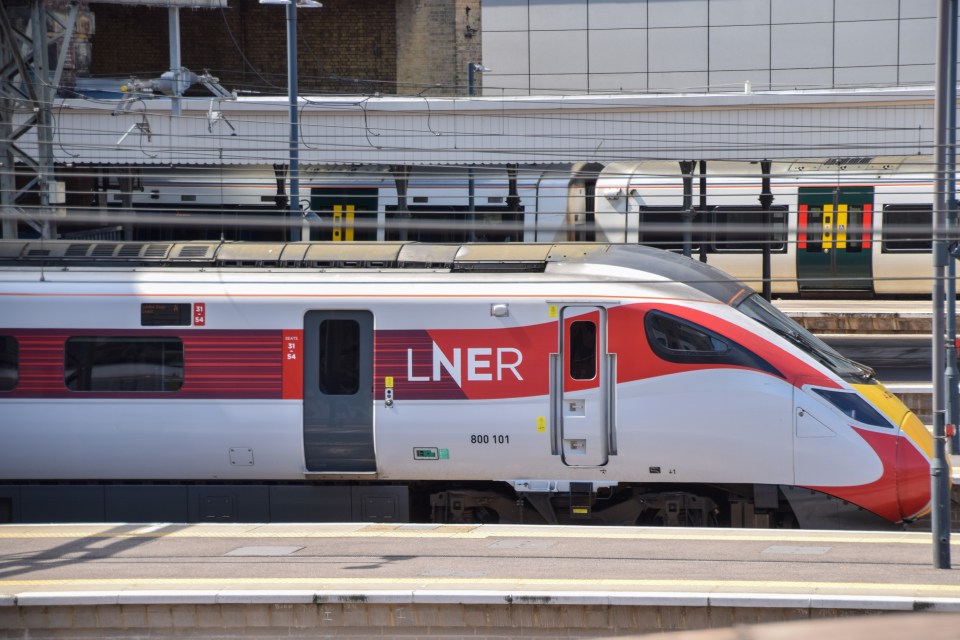 a red and white train with the word lner on the side