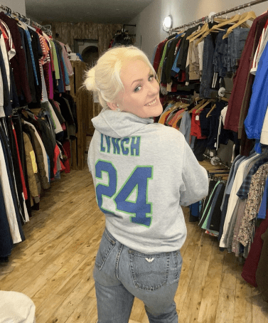 a woman wearing a grey lynch 24 sweatshirt