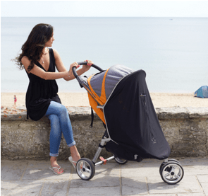 a woman sits on a wall next to a stroller