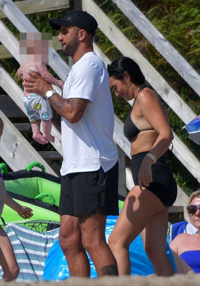 Kyle with wife Annie Kilner on the beach in Wales along with their new baby