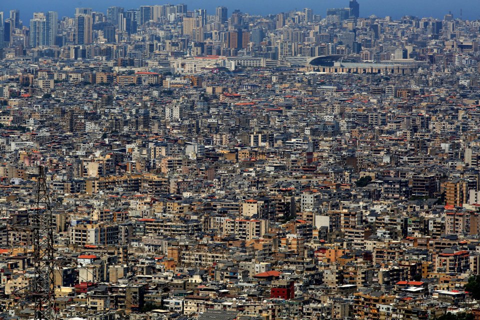 a city with a lot of buildings and a stadium in the background