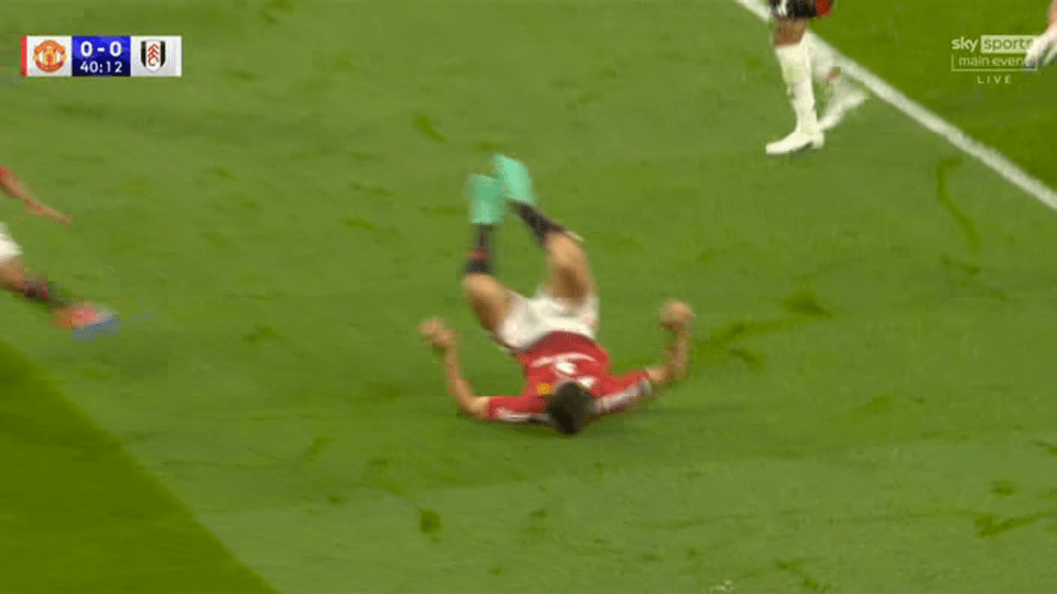 a soccer player is laying on his back on the field .