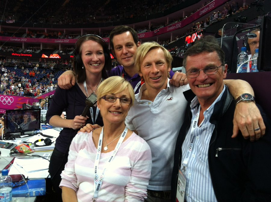 a group of people posing for a picture in front of a london 2012 sign