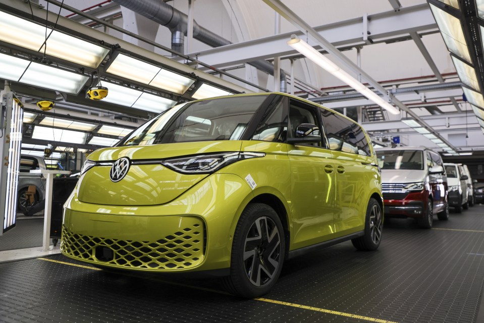 a row of volkswagen vans are lined up in a factory