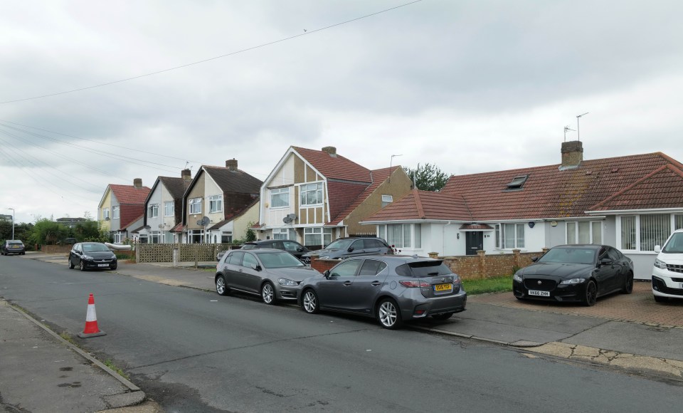 a row of houses with cars parked on the side of the road