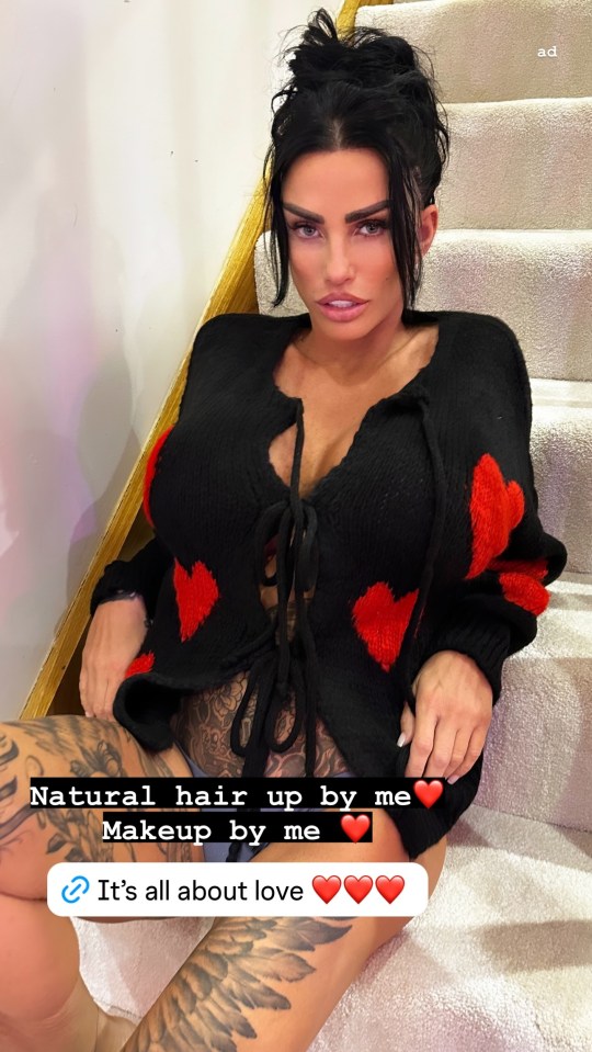 a woman is sitting on a set of stairs wearing a black sweater with red hearts on it