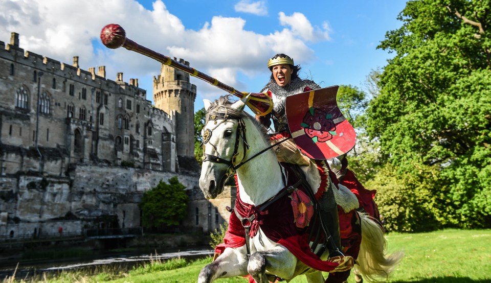 a man in a knight 's armor is riding a horse in front of a castle